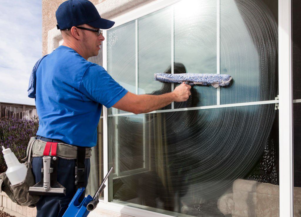 Window cleaner using a squeegee to clean a window